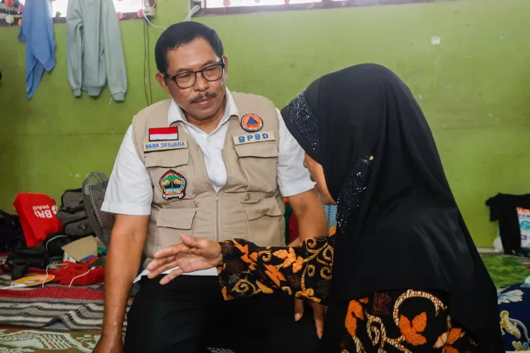 Pj Gubernur Jawa Tengah, Nana Sudjana disela mendampingi Kepala Badan Pangan Nasional (Bapanas) Arief Prasetyo Adi, memberikan bantuan pangan kepada warga korban banjir di Kabupaten Demak,  Minggu, 24 Maret 2024.  (dok Humas Jateng.)