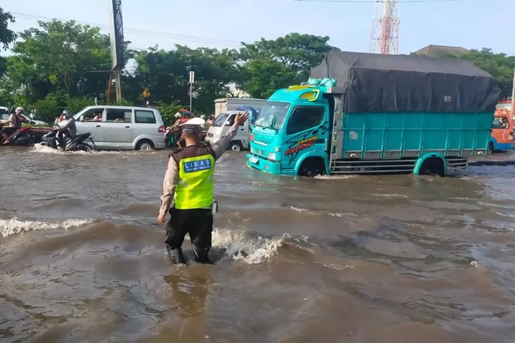 Polisi saat mengatur lalu lintas di Kaligawe Semarang yang banjir lagi. Polisi minta pemudik lewat Pedurungan. (Istimewa)