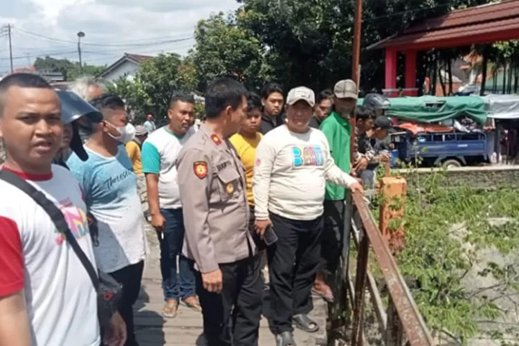 Warga dan polisi saat hendak mengevakuasi jenazah tanpa busana yang terapung di Sungai Talang Semarang.  (Istimewa)