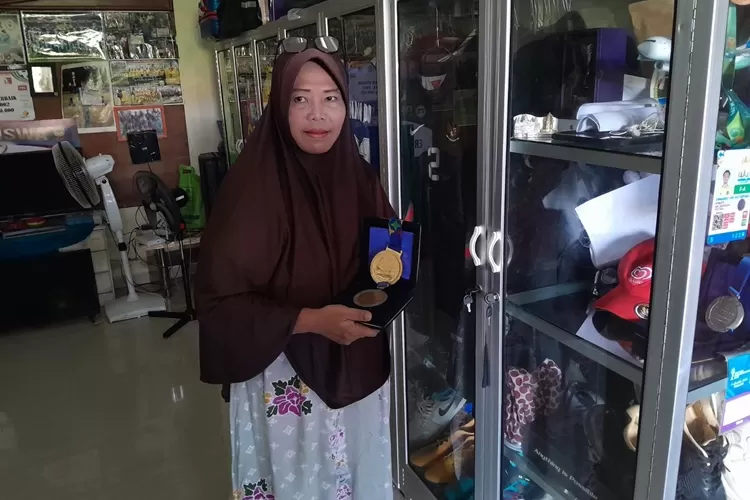 Ibu kiper Timnas Indonesia Ernando Ari Sutaryadi saat memegang medali anaknya. Ibu Ernando tolak anaknya main di PSIS Semarang.  (Ayosemarang.com/ Audrian Firhannusa)