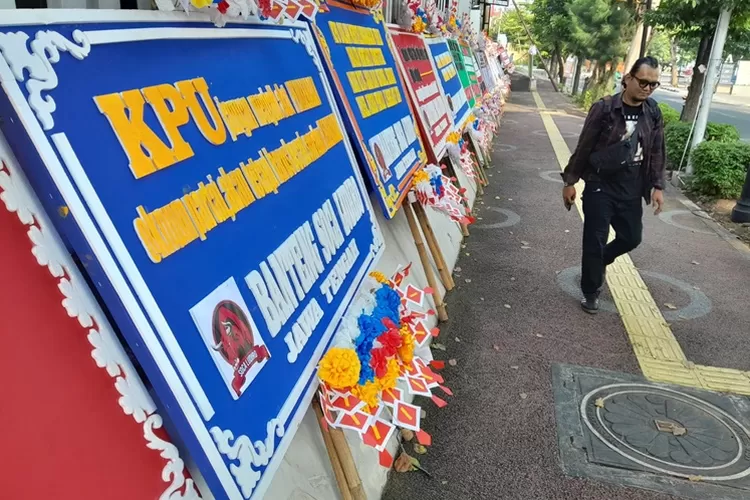 Warga saat melintas di karangan bunga yang dikirim oleh caleg PDIP ke kantor KPU Jateng. Karangan bunga ini sebagai bentuk proses karena mereka terancam gagal dilantik.  (Ayosemarang.com/ Audrian Firhannusa)