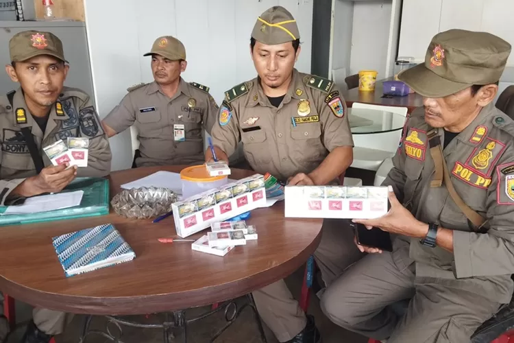 Anggota Satpol PP Batang menunjukkan hasil sitaan rokok ilegal.  (Diskominfo Batang)