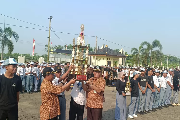 Kepala Sekolah SMKN 1 Warungasem bersama siswa angkat tropi sebagai simbol sang juara. (Istimewa)