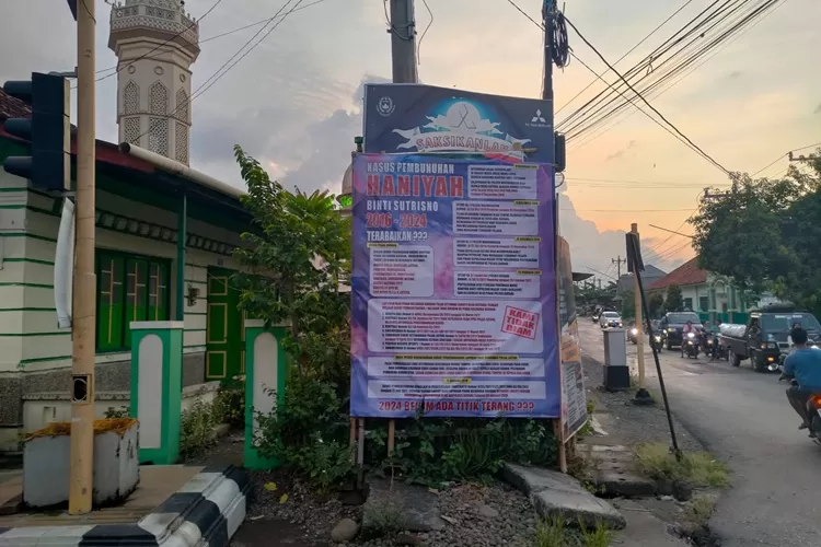 Sebuah baliho raksasa dipasang di pertigaan jalan Pasar Warungasem mempertanyakan kemajuan penyelidikan kasus pembunuhan Haniyah.  (Muslihun kontributor Batang)