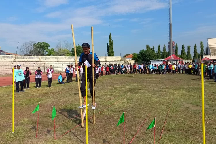 Peserta memainkan egrang dalam lomba olahraga tradisional di Stadion Utama Kebondalem Kendal Rabu 03 Juli 2024.  (edi prayitno/kontributor kendal)