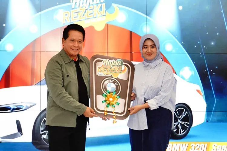 Direktur Utama BSI Hery Gunardi (kanan) menyerahkan hadiah utama  1 (satu) unit mobil BMW 321i kepada nasabah BSI KCP Cianjur Cipanas 2 Siti Rahmawati (kanan) pada acara Seremoni Penyerahan Hadiah Hujan Rezeki BSI Mobile di The Tower Jakarta, Jumat (19/7).