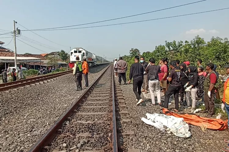 Petugas mengevakuasi tubuh seorang laki-laki tanpa identitas yang tertabrak KA di Desa Sarirejo Kaliwungu Kamis 25 Juli 2024.  (edi  prayitno/kontributor Kendal)