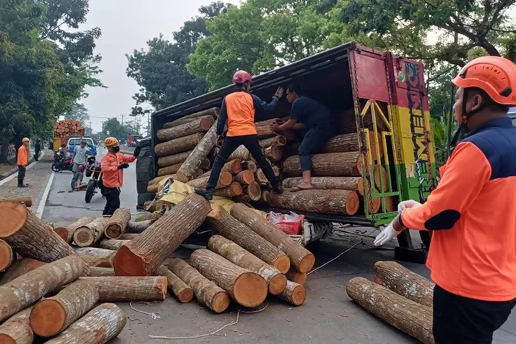 Truk bermuatan kayu terguling menimpa suami istri pengendara motor di Jalan Perintis Kemerdekaan Semarang.  (Istimewa)