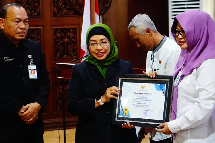 Pj Bupati Batang Lani Dwi Rejeki menyerahkan piagam kepada OPD yang menjadi percontohan.  (Muslihun/Kontributor Batang)