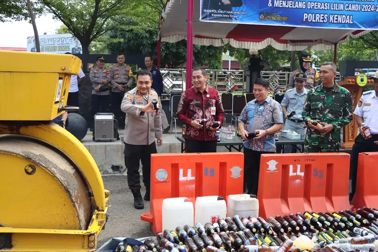 Kapolres dan perwakilan tokoh agama saat memusnahkan miras di halaman Maporles Kendal Jumat 20 desember 2024.  (edi prayitno/kontributor kendal)