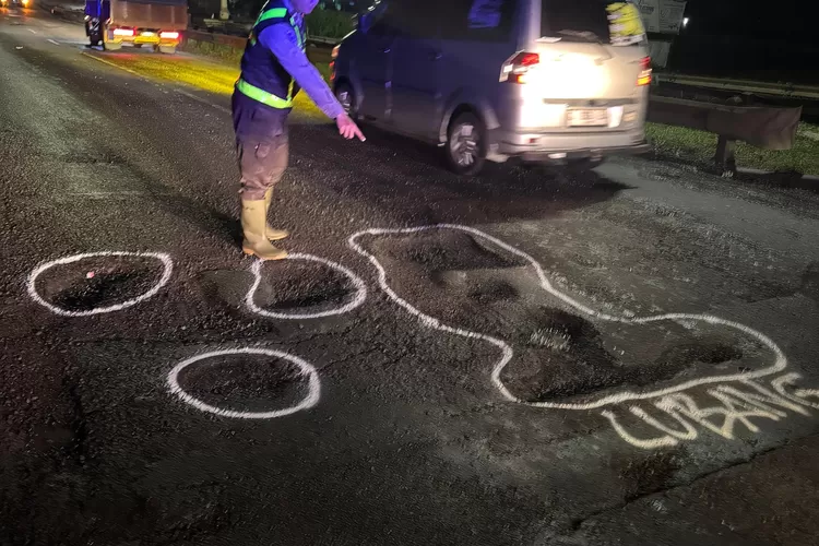  Anggota Satlantas Polres Kendal memberikan tanda bahaya di jalan yang berlubang di sepanjang Pantura Kendal.  (edi prayitno/kontributor Kendal)