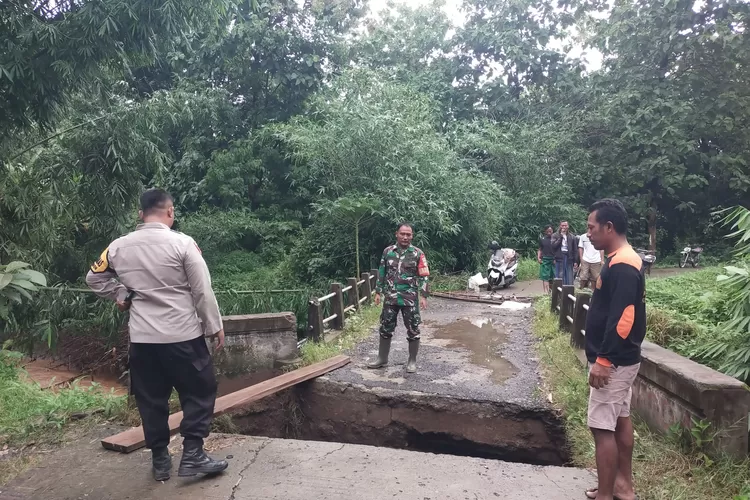 Bhabinkamtibmas dan Babinsa mengecek jembatan yang ambrol akibat longsor di Dukuh Pidik Desa Wonosari Pegandon.  (edi prayitno/kontributor Kendal  &nbsp;)