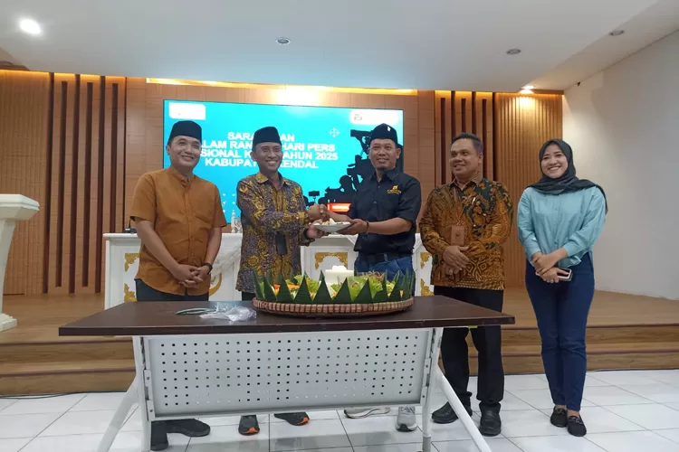 Pj Sekda Kendal menyerahkan potongan tumpeng kepada Ketua Forwaken dalan sarasehan HPN 2025.  (edi prayitno/kontributor kendal)