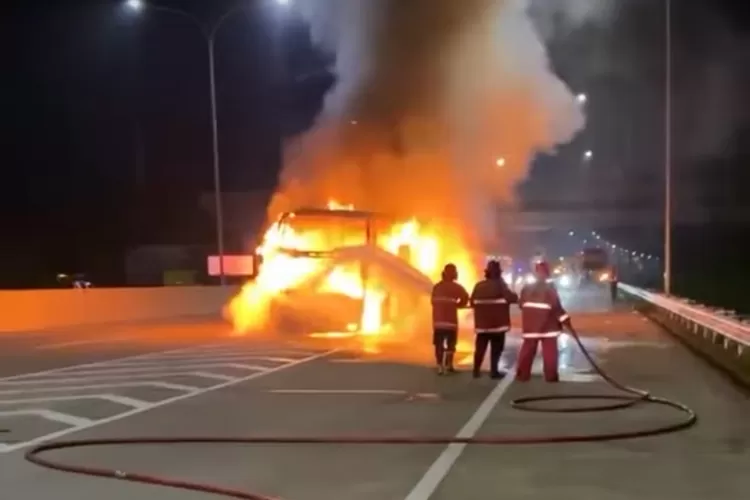 Petugas memadamkan api yang membakar Bus Shantika Bangun Perkasa di jalan tol Semarang-Batang KM 408 exit tol Kaliwungu, Sabtu 01 Maret 2025 dinihari.  (edi prayitno/ kontributor Kendal)