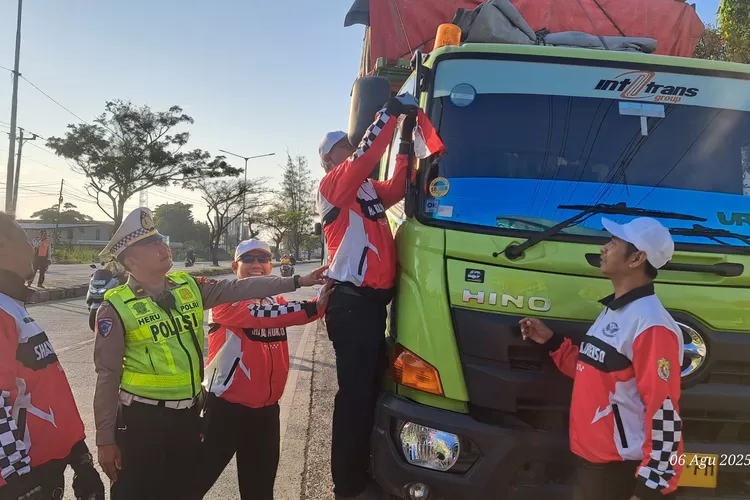 Satlantas Polres Kendal bersama komunitas motor membagikan bendera Merah Putih di Jalur Pantura kepada truk yang melintas.  (edi prayitno/kontibutor kendal)