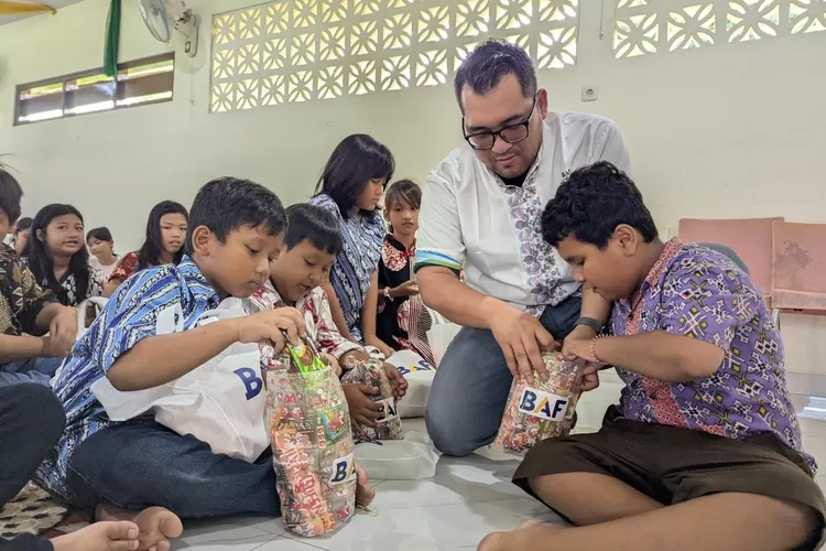Eko Prasetyo Budianto, Regional Center Head BAF Semarang membuka bingkisan akhir tahun bersama anak-anak Panti Asuhan Bethlehem Bala Keselamatan dalam CSR BAF Nutri-Kids. (Dok BAF)
