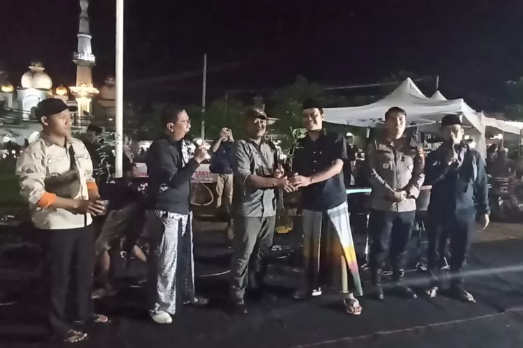 Pengasuh Madrasah Budaya dan Kapolsek Kaliwungu menerima bibit tanaman dalam aksi pray for sumatera yang dilaksanakan di RTH Alun-alun Kaliwungu Sabtu 20 desember 2025.  (Edi prayitno/kontributor kendal)