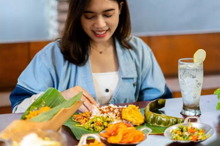 Menyantap hidangan beralaskan daun di objek wisata kuliner Bandung Alas Daun  (Foto/Instagram/@alas.daun)