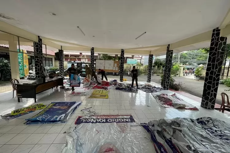 RAPIHKAN : Satpol PP Kecamatan Pancoranmas saat merapihkan atribut sejumlah Parpol yang ditertibkan di jalan utama pada wilayahnya. (GERARD SOEHARLY/RADAR DEPOK)