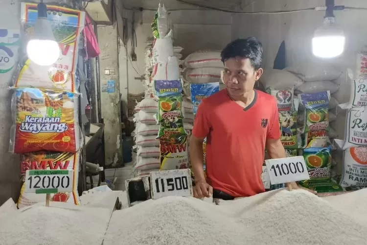 Pedagang beras di Pasar Agung, Kecamatan Sukmajaya, Kota Depok saat menunjukan harga beras yang dijualnya, beberapa waktu lalu.  (DOK. RADAR DEPOK)