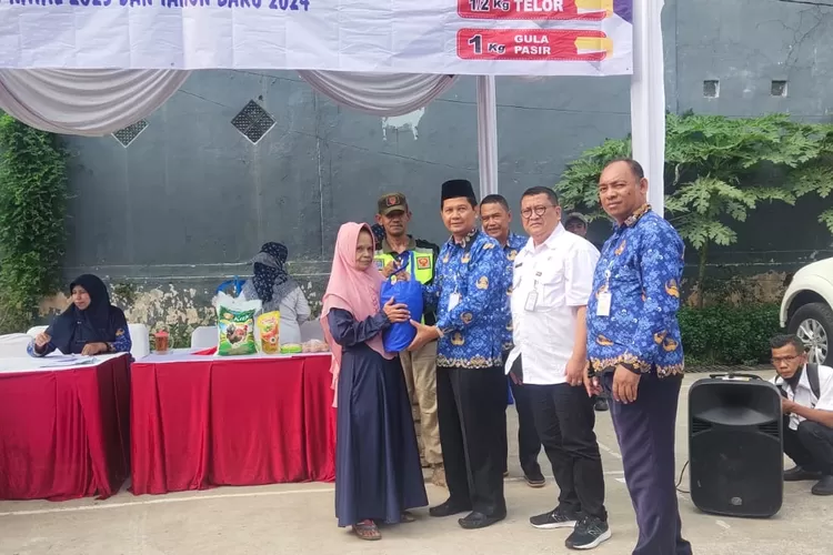 Aparatur Kelurahan Cimpaeun, Kecamatan Tapos memantau pembagian sembako di halaman kantor kelurahan. (Andika Eka )