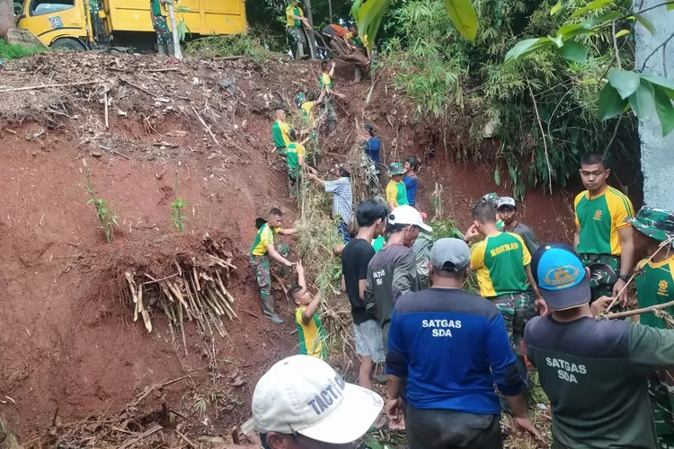 Koramil Sukmajaya melaksanakan Karya Bakti untuk mengangkut material longsor di RT3/6 Kelurahan Cilodong, Kecamatan Cilodong, Kota Depok. (Andika Eka )
