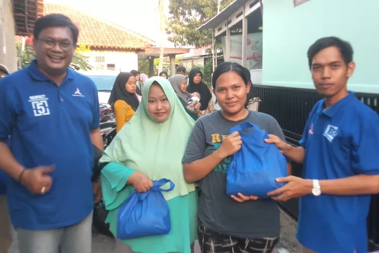 Caleg DPRD Kota Depok Partai Demokrat Dapil 3 Cimanggis, Ferry Apriyanto (Kiri) dan salah satu tim pemenangan Budi Purnomo (Kanan) memberikan pangan murah kepada warga RW7, Kelurahan Tugu, Kecamatan Cimanggis. (ANDIKAEKA/RADARDEPOK)