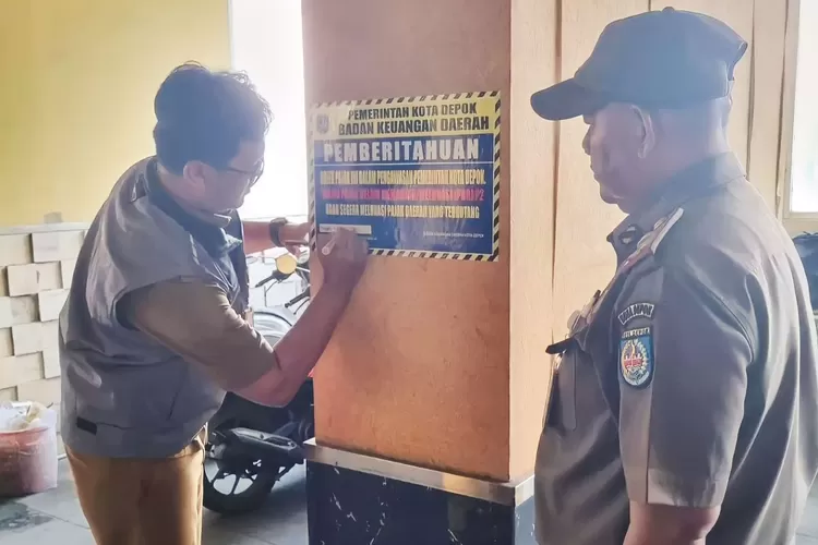 Petugas pajak BKD Depok tengah memberikan sanksi kepada restoran dengan memasang stiker, belum lama ini. (RADAR DEPOK)