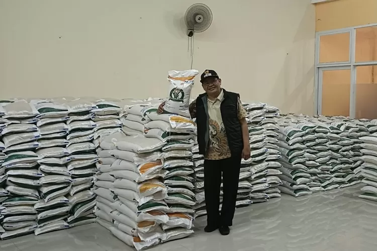 Lurah Jatijajar, Mujahidin melakukan menyerahkan bantuan beras kepada masyarakat, di aula Kelurahan Jatijajar, Kecamatan Tapos. (ANDIKA EKA/RADAR DEPOK)