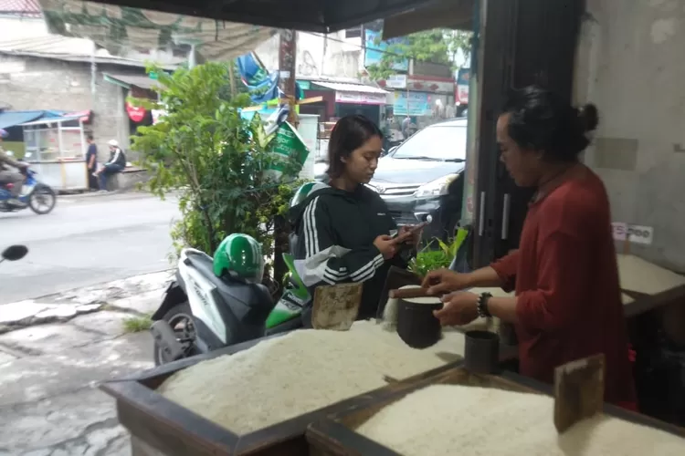 Proses transaksi jual beli beras di toko beras mulia, yang terletak di Jalan Kemakmuran, Kelurahan Mekarjaya, Kecamatan Sukmajaya, Selasa (6/2/2024) (ANDIKA EKA/RADAR DEPOK)