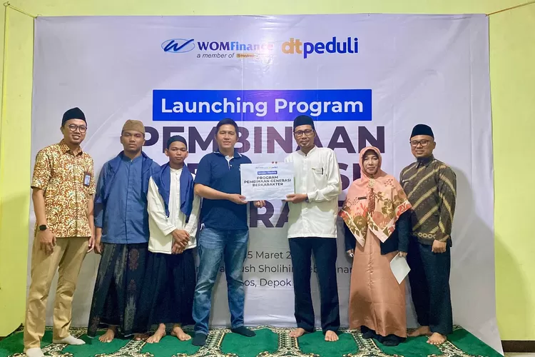 Financial Planning and Investor Relation Division Head WOM Finance, Erik Tanudjaja bersama perwakilan Yayasan Riyadush Shalihin, Ahmad Bahrudin