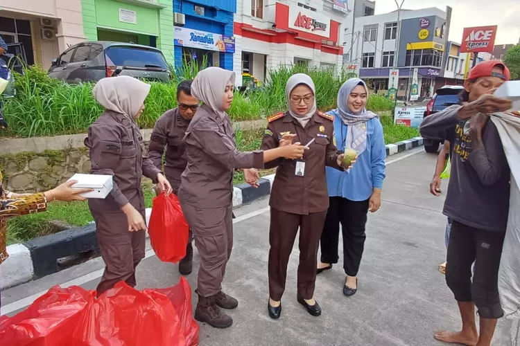 Kepala Kejari Kota Depok, Silvia Desty Rosalina membagikan takjil kepada para pengendara di Jalan Raya Grand Depok City (GDC), Kelurahan Tirtajaya, Kecamatan Sukmajaya. (ANDIKA EKA/RADAR DEPOK)