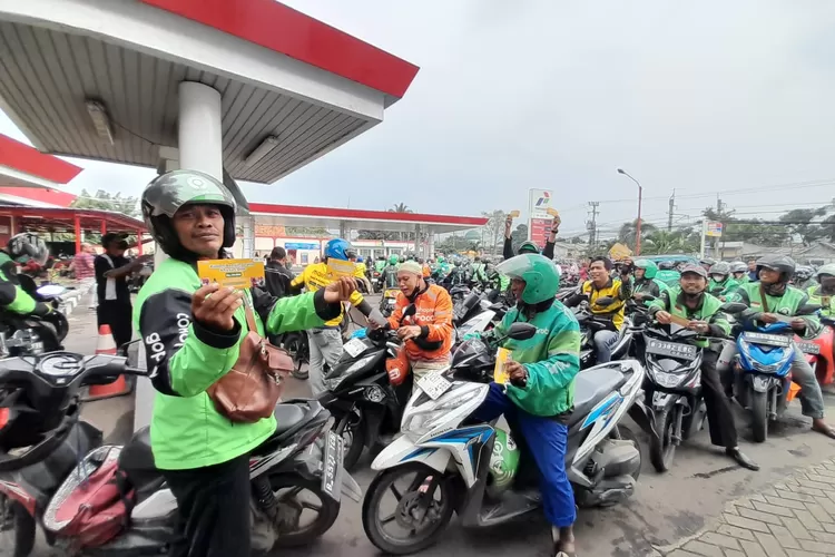 Ratusan Ojol mengantre untuk &nbsp;mendapatkan voucher isi bensin gratis dan nasi box gratis, dari Yayasan Khadimul Ummah Madani di SPBU Kelurahan Pondok Jaya, Kecamatan Cipayung, Kota Depok, Kamis (28/3). (AGNESYA WIANDA/RADAR DEPOK)