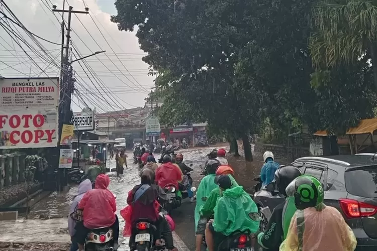 Situasi banjir di Jalan Raya KSU, Kelurahan Tirtajaya, Kecamatan Sukmajaya, membuat kendaraan lalu lintas menjadi tersendat, Minggu (5/5). (RADAR DEPOK)