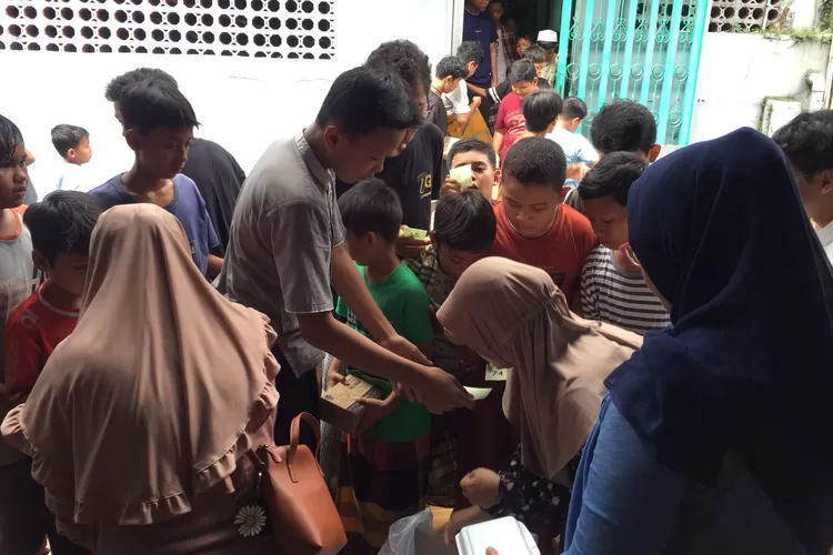 Suasana Poktan 2 PKK RW 10 saat pembagian nasi kotak dalam kegiatan Jumat Berkah di Masjid Al Hikmah, Kelurahan Mekarjaya, Kecamatan Sukmajaya, Jumat (24/5).  (AGNESYA WIANDA/RADAR DEPOK)