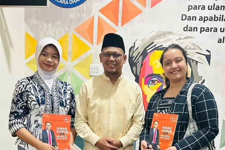 Wakil Walikota Depok Imam Budi Hartono (Tengah) memberikan buku autobiografinya berjudul Anak Supir Jadi Wakil Walikota kepada Fatiyah (Kiri) dan Gloria (Kanan) saat berkunjung ke Balaikota Depok, Jumat (7/6). (RADAR DEPOK)