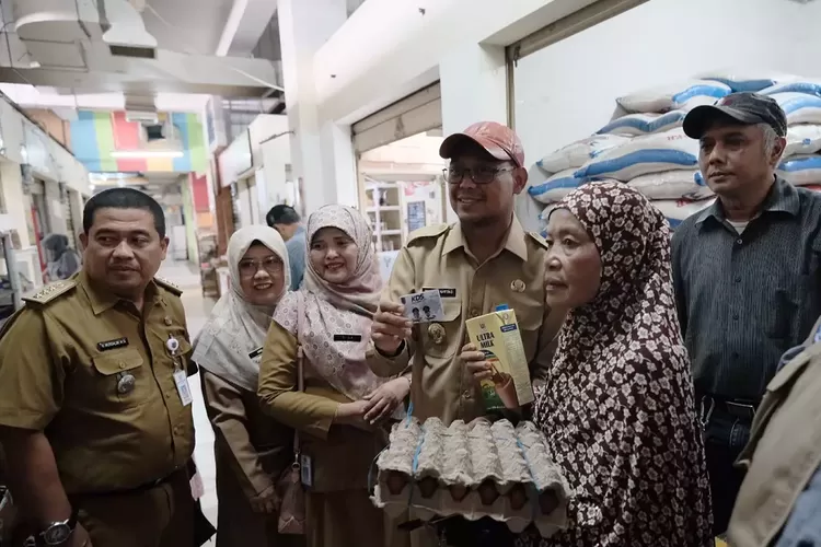 Wakil Walikota Depok, Imam Budi Hartono (topi orange), saat memberikan Bantuan Pangan Kota (BPK) program KDS kepada ratusan warga di Pasar Segar, Kecamatan Cinere, Senin (10/6). (PEMKOT DEPOK)