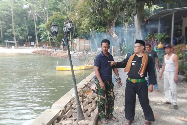 Lurah Jatijajar, Mujahidin bersama ketua Pokdarwsis Situ Jatijajar pemantau pembangunan revitasliasi situ dari Pemprov Jabar. (ANDIKA EKA/RADAR DEPOK)