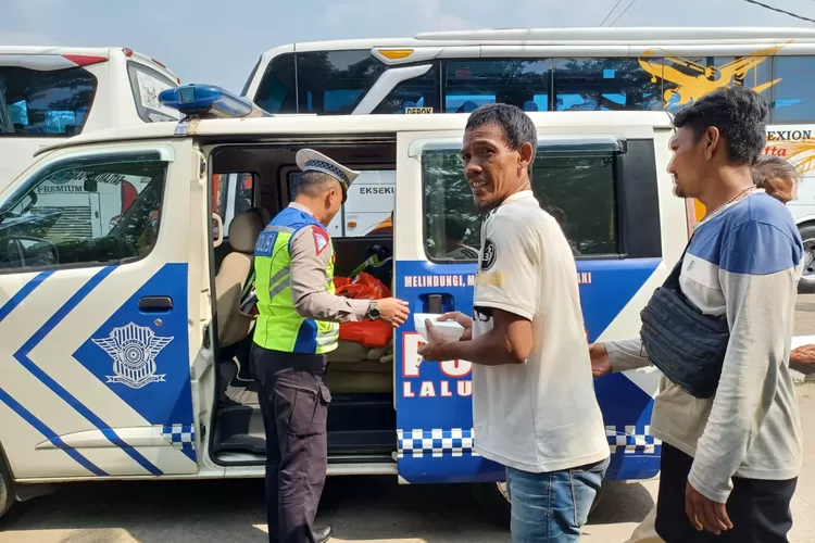 Anggota Subnit Kamsel Polres Metro Depok sedang membagikan jumat berkah di Terminal Depok Bus Margonda, Jumat (12/7/2024) (MONICA REISTIE/RADAR DEPOK)