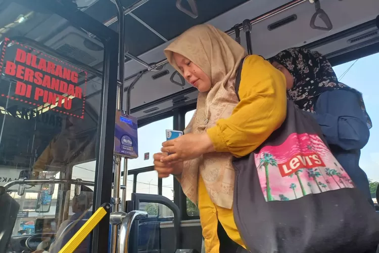 Salah satu pengguna layanan BisKita Trans Depok yang sedang turun dari bus. (ANDIKA EKA/RADAR DEPOK)