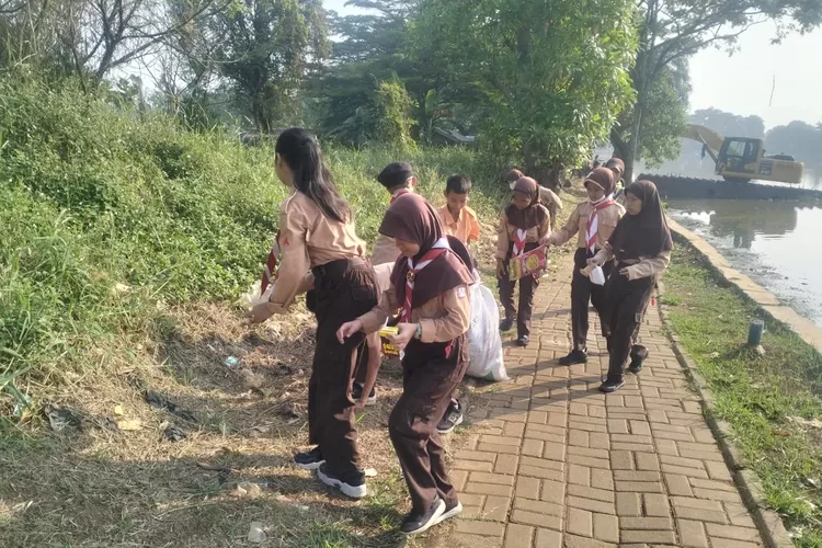 KOMPAK : Siswa SDN Pengasinan 3 saat melakukan aksi bersih-bersih di sekitar Situn Pengasinan, Kecamatan Sawangan, Kota Depok, akhir pekan kemarin. (DOKUMENTASI NARASUMBER )