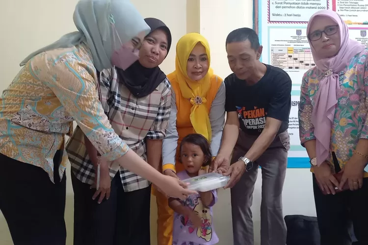 SIMBOLIS : Lurah Curug, Hasan saat menyerahkan Pemberian Makanan Tambahan (PMT) lokal kepada Balita yang berlangsung di Kantor Kelurahan Curug, Kecamatan Bojongsari, Kota Depok, Jumat (13/9). (DOKUMENTASI NARASUMBER)