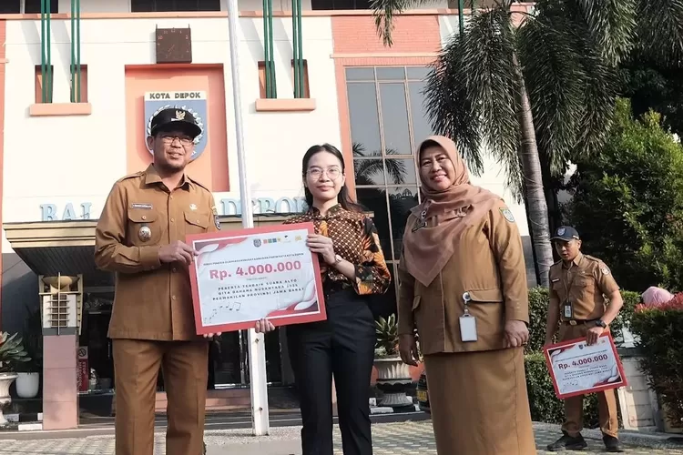 Wakil Walikota Depok, Imam Budi Hartono didampingi Pj Sekda Depok, Nina Suzana menyerahkan secara simbolis uang pembinaan kepada Celine Caroline yang meraih juara untuk kategori suara alto di ajang audisi GBN tingkat Jabar 2024.
