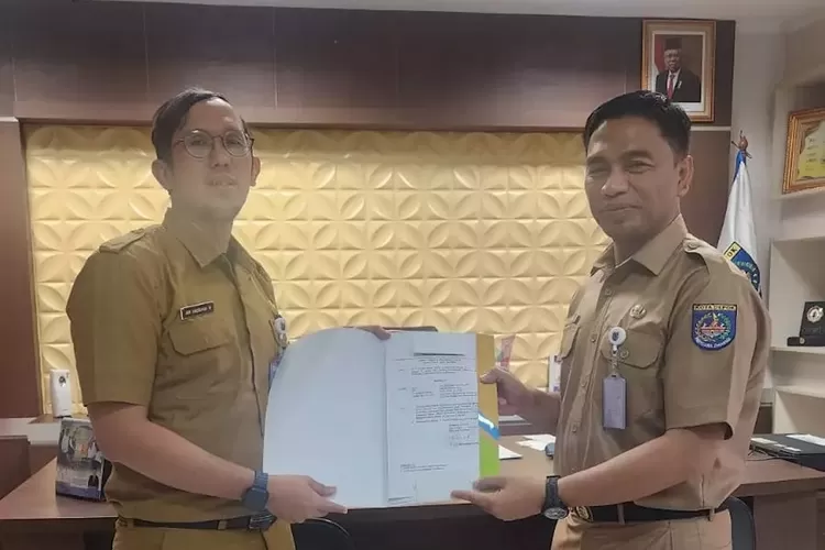 Ari Andriyana Wijaya (kiri) saat menerima surat keputusan menjadi Plt Lurah Dumek dari Kepala BKSDM Kota Depok, Rahman Pujiarto (kanan).