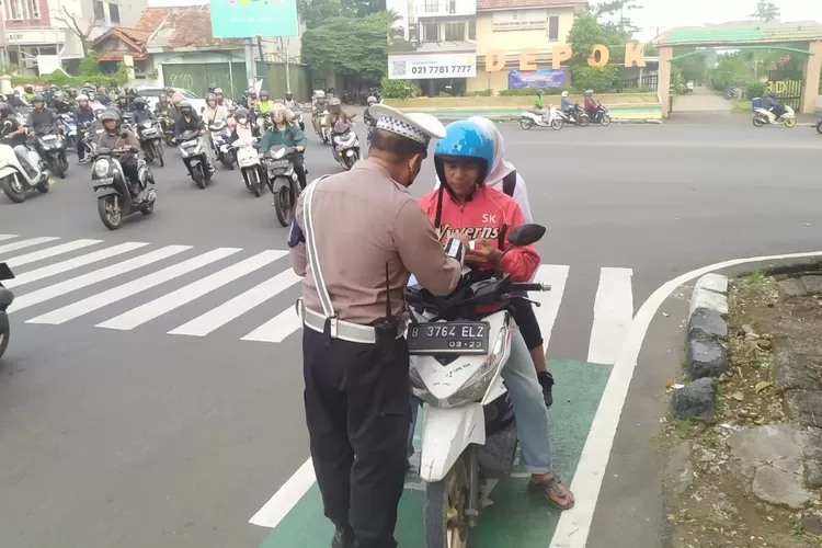 Petugas Lalu Lintas Polres Metro Depok saat menindak salah satu pengendara yang melanggar di Lampu Merah Jalan Juanda, Kota Depok. (ANDIKA EKA/RADAR DEPOK)
