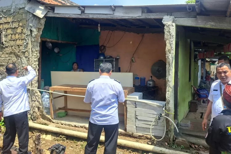 TINJAU : Camat Bojongsari, Rijal Farhan bersama Lurah Bojongsari, Yaya Sudira saat meninjau tembok rumah warga yang jebol di Gang Remot, RT1/2, Kelurahan/Kecamatan Bojongsari, Kota Depok, Rabu (20/11). (ALDY RAMA/RADAR DEPOK)