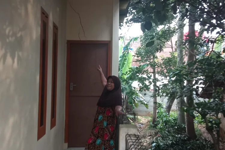 PEMBANGUNAN: Warga Kampung Pasir Kalong, Desa Sukakarya, Kecamatan Megamendung, menunjukan retakan tembok pada rumahnya.  (FOTO : Achmad Kurniawan/Radar Depok)