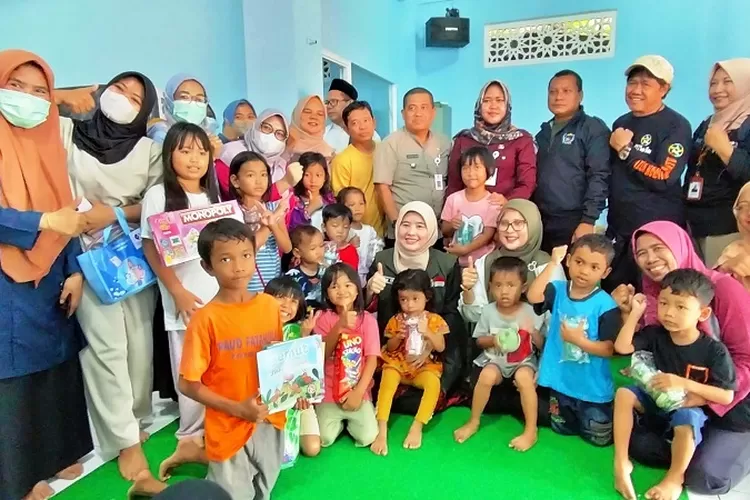 Puluhan anak dan ibu foto bersama dengan Ketua Jabar Bergerak Kota Depok, Siti Barkah yang didampingi Camat Cinere Mursalim Saimin, dan Lurah Pangakalanjati Baru (PJB) Ayu Dwi Pratiwi, selepas memberikan motivasi dan bantuan. (FAHMI/RADAR DEPOK)