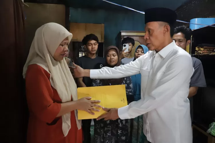 Wabup Jaro Ade menyerahkan bantuan kepada keluarga korban pasutri hanyut.