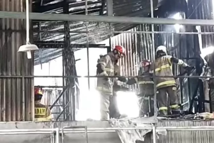 Petugas Damkar Kota Depok saat berjibaku memadamkan api yang melahap Bengkel Omega di Jalan Raya Siliwangi, Kelurahan Depok, Kecamatan Pancoranmas, Rabu (12/3/2025).  (FOTO DAMKAR KOTA DEPOK)
